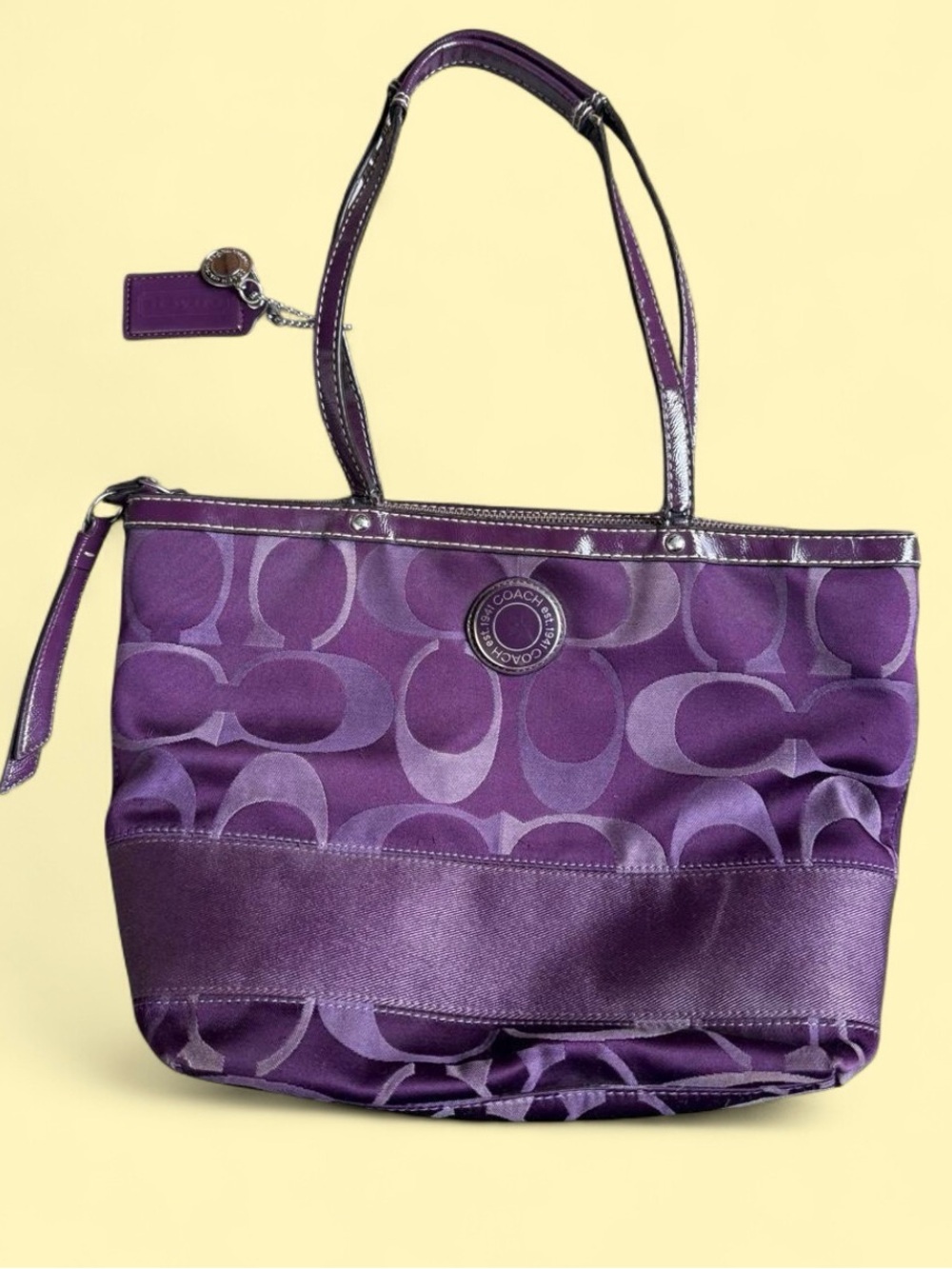 Coach Signature Sateen Taylor Tote in a vibrant purple colorway, manufactured in